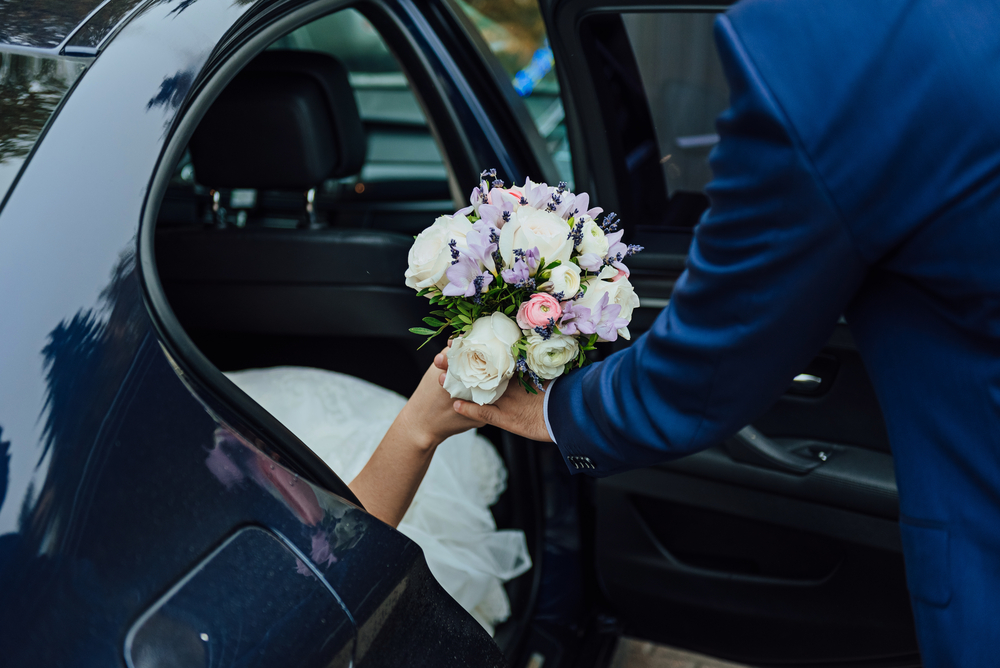 Groom assisting bride into luxury wedding chauffeur car in Melbourne with VHA Limos wedding transfer service