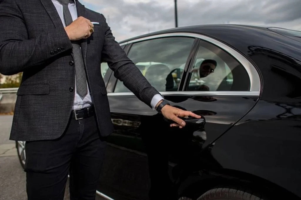 Professional chauffeur opening luxury car door for hotel transfer in Melbourne with VHA Limos