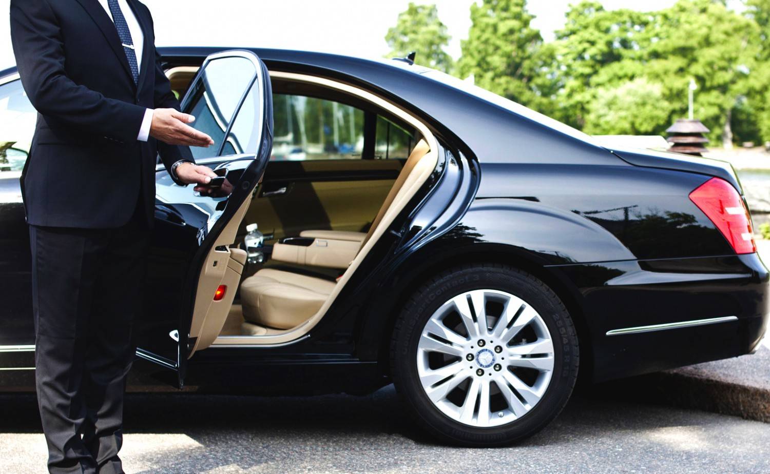 Professional chauffeur opening luxury car door in Melbourne with VHA Limos premium chauffeur service